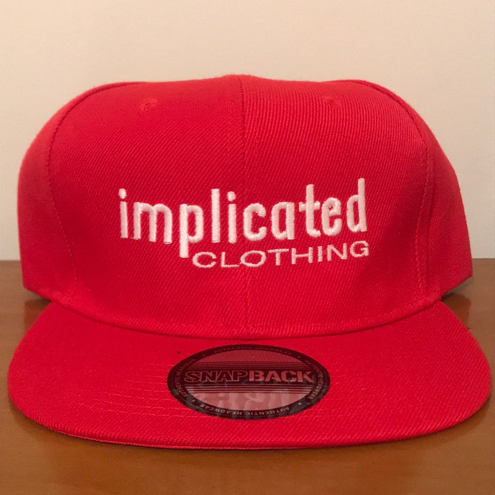 Red “Implicated Clothing” snap back hat